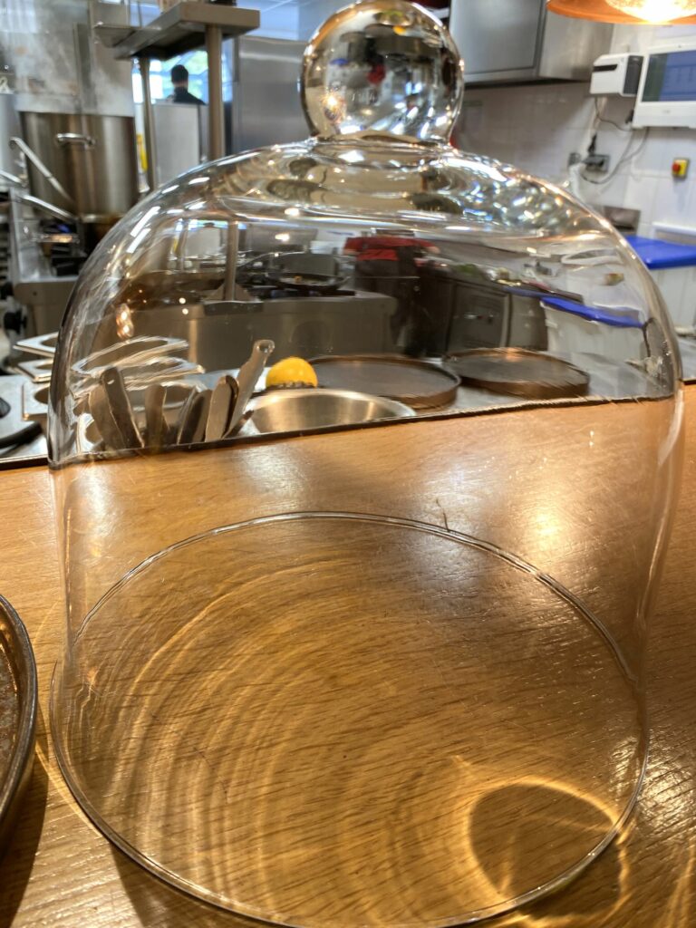 Cloche de service sur le passe du restaurant Félicie, préparer l'ouverture d'un restaurant avec une salle pleine