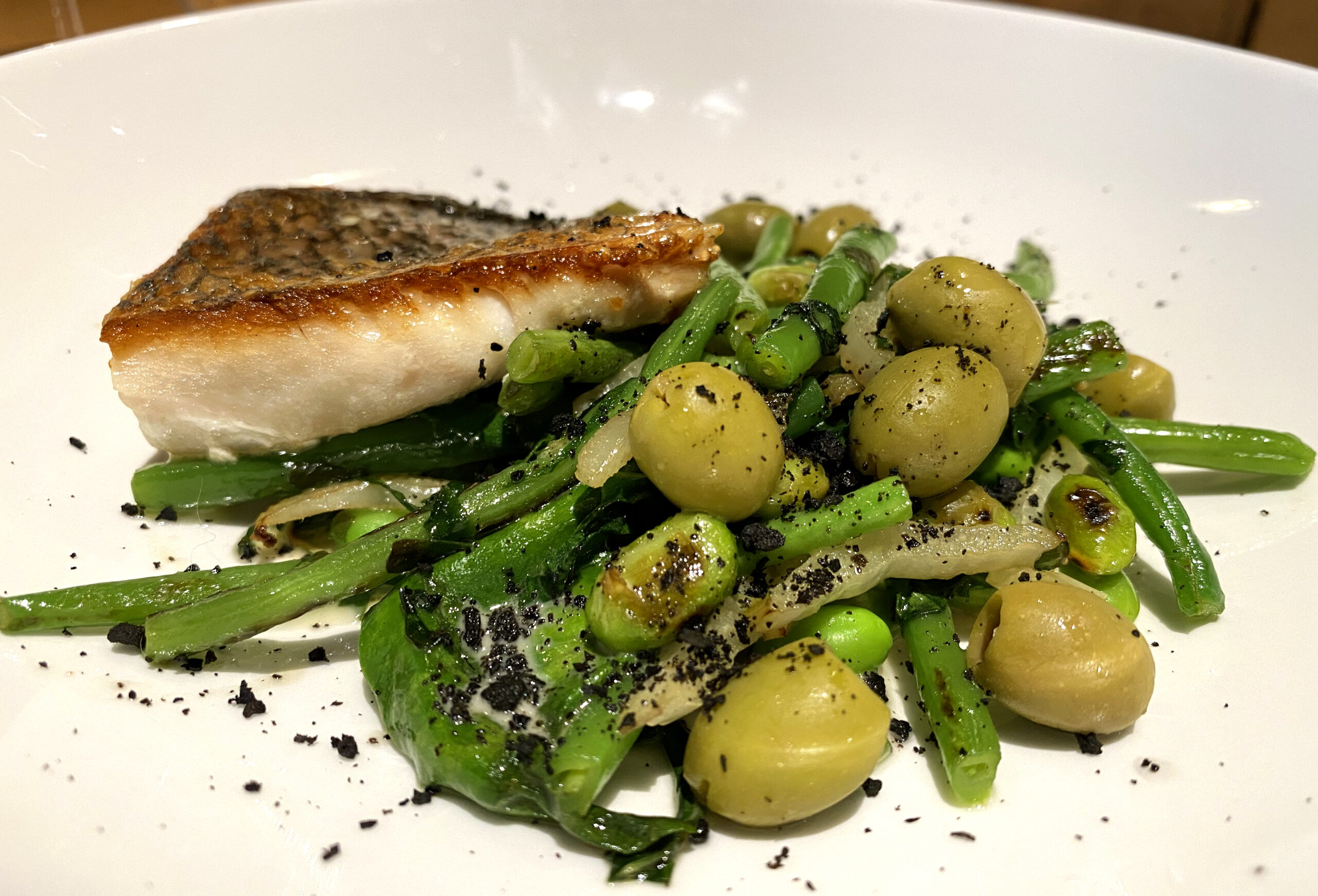 Perche, petits pois, olives et haricots verts — une assiette monochrome verte de printemps
