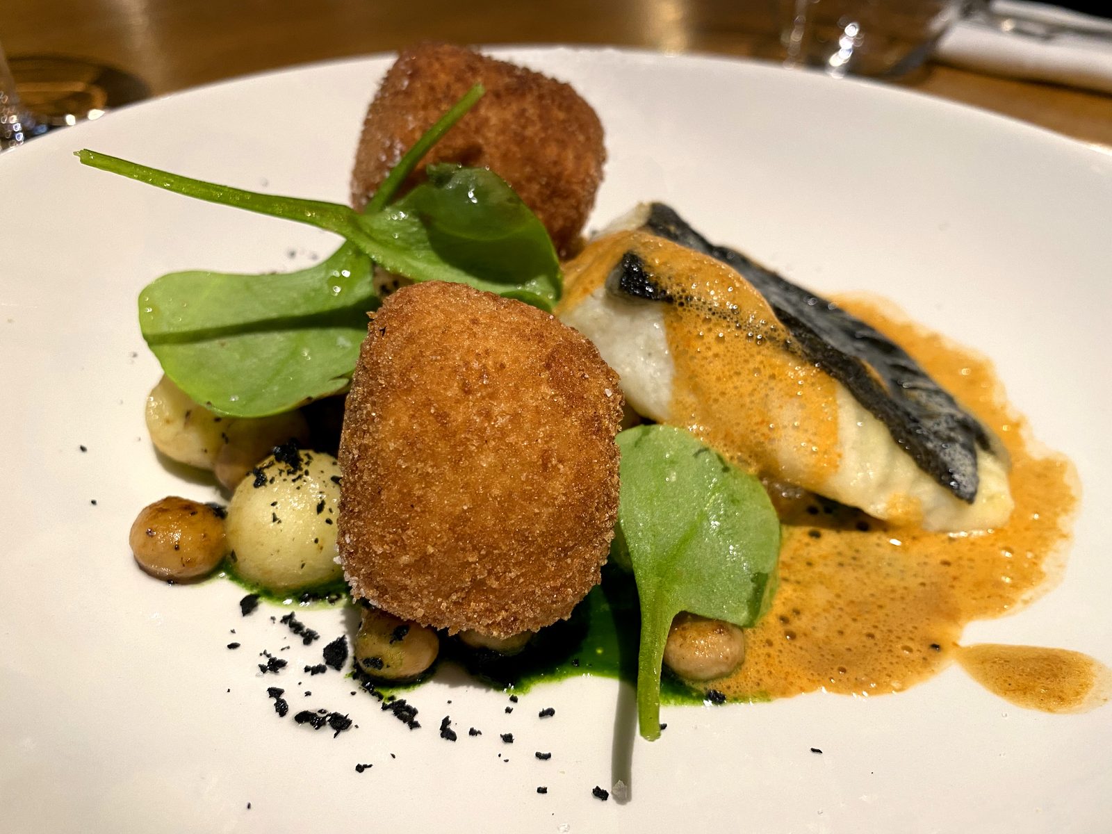 Turbot, bisque et croquette de homard, épinards et billes de pomme de terre — six saveurs dans une assiette